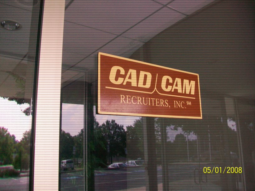 Sign for CAD CAM Recruiters, Inc. displayed on a glass entrance, indicating its presence and focus on specialized recruitment services.